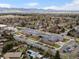 Overhead view of a neighborhood and school surrounded by lush trees, showcasing a tranquil community at 10335 W 18Th Pl, Lakewood, CO 80215
