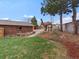 Large grassy backyard with a tree house, some landscaping, and a brick home exterior at 10335 W 18Th Pl, Lakewood, CO 80215