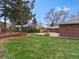 Expansive backyard with healthy grass, a wooden deck with seating, and a brick home exterior at 10335 W 18Th Pl, Lakewood, CO 80215
