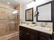 Bathroom with double sinks, shower with glass door, and a dark wood vanity at 10335 W 18Th Pl, Lakewood, CO 80215