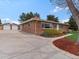 Charming brick home featuring a well-manicured lawn, tasteful landscaping, and an expansive driveway at 10335 W 18Th Pl, Lakewood, CO 80215
