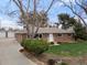Charming single-story brick home with a well-manicured front lawn and mature trees on a sunny day at 10335 W 18Th Pl, Lakewood, CO 80215