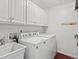 Well-lit laundry room with white cabinetry, sink, and modern washer and dryer for convenient chores at 10335 W 18Th Pl, Lakewood, CO 80215