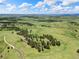 Lush acreage with scattered trees and a long dirt driveway leading to the home at 1752 Private Road 130, Elizabeth, CO 80107