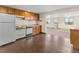 Traditional kitchen with wood cabinets, white appliances, and a pass-through to another room at 1752 Private Road 130, Elizabeth, CO 80107