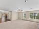Large living space features neutral carpet, a ceiling fan, lots of light, and a pass through to the kitchen at 1752 Private Road 130, Elizabeth, CO 80107