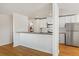 Bright kitchen with white cabinetry, stainless steel appliances, and a breakfast bar at 1180 S Monaco Pkwy # 3, Denver, CO 80224