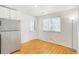 Open-concept kitchen area, featuring a stainless steel refrigerator and hardwood flooring at 1180 S Monaco Pkwy # 3, Denver, CO 80224