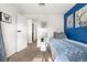 Bright bedroom with blue accent wall, side table, and blue and white comforter at 7132 Xavier Way, Westminster, CO 80030