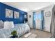 Bright bedroom featuring a striking blue accent wall, modern decor, and a sunny window at 7132 Xavier Way, Westminster, CO 80030