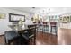 Open-concept dining area featuring hardwood floors, bar seating, and stylish decor with a large rustic table at 7132 Xavier Way, Westminster, CO 80030