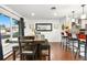 Dining area with hardwood floors, rustic wooden table and chairs, and bar seating in a well-lit, open space at 7132 Xavier Way, Westminster, CO 80030