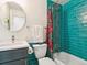 Modern bathroom featuring blue tiling in the shower, new fixtures, and vanity mirror at 207 Iowa Dr, Golden, CO 80403