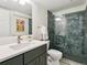 Updated bathroom featuring a vanity and glass enclosed shower with unique blue tiling at 207 Iowa Dr, Golden, CO 80403