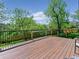 A wooden deck with black metal railing overlooks a lush green backyard on a sunny day at 207 Iowa Dr, Golden, CO 80403