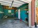 An open garage with peeling turquoise paint, showing its potential for renovation at 207 Iowa Dr, Golden, CO 80403