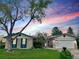 Charming single-story home featuring well-maintained lawn and beautiful sunset at 3026 S Alton Ct, Denver, CO 80231