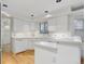 Bright kitchen featuring white cabinets, tile backsplash, and hardwood floors at 3026 S Alton Ct, Denver, CO 80231