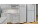 Bright kitchen featuring white cabinets, modern appliances, and hardwood floors at 3026 S Alton Ct, Denver, CO 80231
