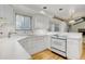 Well-lit kitchen with white cabinetry, modern stove, and hardwood floors at 3026 S Alton Ct, Denver, CO 80231