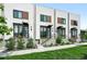 Modern townhome exterior with beautiful front yard landscaping and individual entryways with dark metal awnings and railings at 4394 Zenobia St, Denver, CO 80212