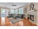Cozy living room with hardwood floors, fireplace, and large windows providing ample light at 7211 Dolomite Ln, Castle Rock, CO 80108