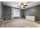 A bedroom with gray walls, carpeted floors, a ceiling fan, and a bright window with white curtains at 4286 S Cole St, Morrison, CO 80465