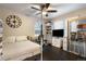 Well-lit bedroom features a ceiling fan, a desk area, dark hardwood flooring, and a decorative display case at 4286 S Cole St, Morrison, CO 80465