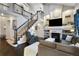 Living room featuring a fireplace, high ceilings, hardwood floors, and a staircase at 4286 S Cole St, Morrison, CO 80465