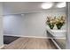 Hallway featuring light wood floors, neutral walls, and mirrored accent wall with flower display at 7255 E Quincy Ave # 403, Denver, CO 80237