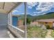 Serene view from the porch overlooking a backyard with a white fence, garden beds, and scenic mountain views at 1324 Virginia St, Idaho Springs, CO 80452