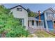 Charming two-story house featuring a cozy porch and a bright red door, with a backdrop of lush greenery at 1324 Virginia St, Idaho Springs, CO 80452