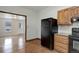 Bright kitchen featuring a black refrigerator, wood cabinets, and open access to the next room at 1324 Virginia St, Idaho Springs, CO 80452