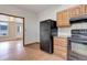 An open kitchen showcases wooden cabinets and black appliances at 1324 Virginia St, Idaho Springs, CO 80452