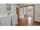 Bright laundry area with washer, dryer, and hardwood floors leading to bonus area at 1324 Virginia St, Idaho Springs, CO 80452
