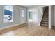 Bright living room boasts hardwood floors, staircase, and a view to a quaint front yard at 1324 Virginia St, Idaho Springs, CO 80452