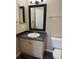 A bathroom featuring a vanity with black countertop, white vessel sink, toilet, and a mirror above the sink at 4338 N Ceylon Ct, Denver, CO 80249