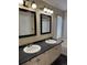 Bathroom featuring double sinks, a large mirror, and tile flooring at 4338 N Ceylon Ct, Denver, CO 80249