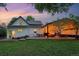 Evening shot of backyard with a lush lawn and outdoor covered patio featuring cozy seating and string lights at 6830 Lamar St, Arvada, CO 80003