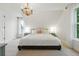 Bright bedroom featuring a statement chandelier, neutral walls, and multiple windows for plenty of natural light at 6830 Lamar St, Arvada, CO 80003