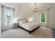Serene bedroom with neutral decor, chandelier, and natural light provides a relaxing retreat at 6830 Lamar St, Arvada, CO 80003