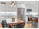 Bright kitchen with stainless steel appliances, white cabinets, stylish lighting, and hardwood floors at 6830 Lamar St, Arvada, CO 80003