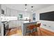 Well-lit kitchen featuring a stylish island, stainless steel appliances, and modern white cabinetry at 6830 Lamar St, Arvada, CO 80003
