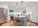 Charming kitchen with a functional island, stainless steel appliances, and modern pendant lighting at 6830 Lamar St, Arvada, CO 80003