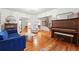 Spacious living room featuring hardwood floors, piano, and plenty of natural light at 6830 Lamar St, Arvada, CO 80003