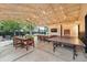 Spacious covered patio equipped with dining, lounge area, ping pong, and a mounted TV at 6830 Lamar St, Arvada, CO 80003
