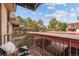 A cozy balcony with a view of trees and covered parking at 7755 E Quincy Ave # 207A3, Denver, CO 80237
