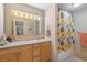 This bathroom has a spacious vanity and a floral shower curtain at 7755 E Quincy Ave # 207A3, Denver, CO 80237
