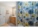 Bright bathroom featuring floral shower curtain, vanity, and modern lighting at 7755 E Quincy Ave # 207A3, Denver, CO 80237