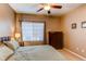 A relaxing bedroom boasts a ceiling fan, a large window, a wooden dresser, and neutral tones at 1651 W Canal Cir # 613, Littleton, CO 80120
